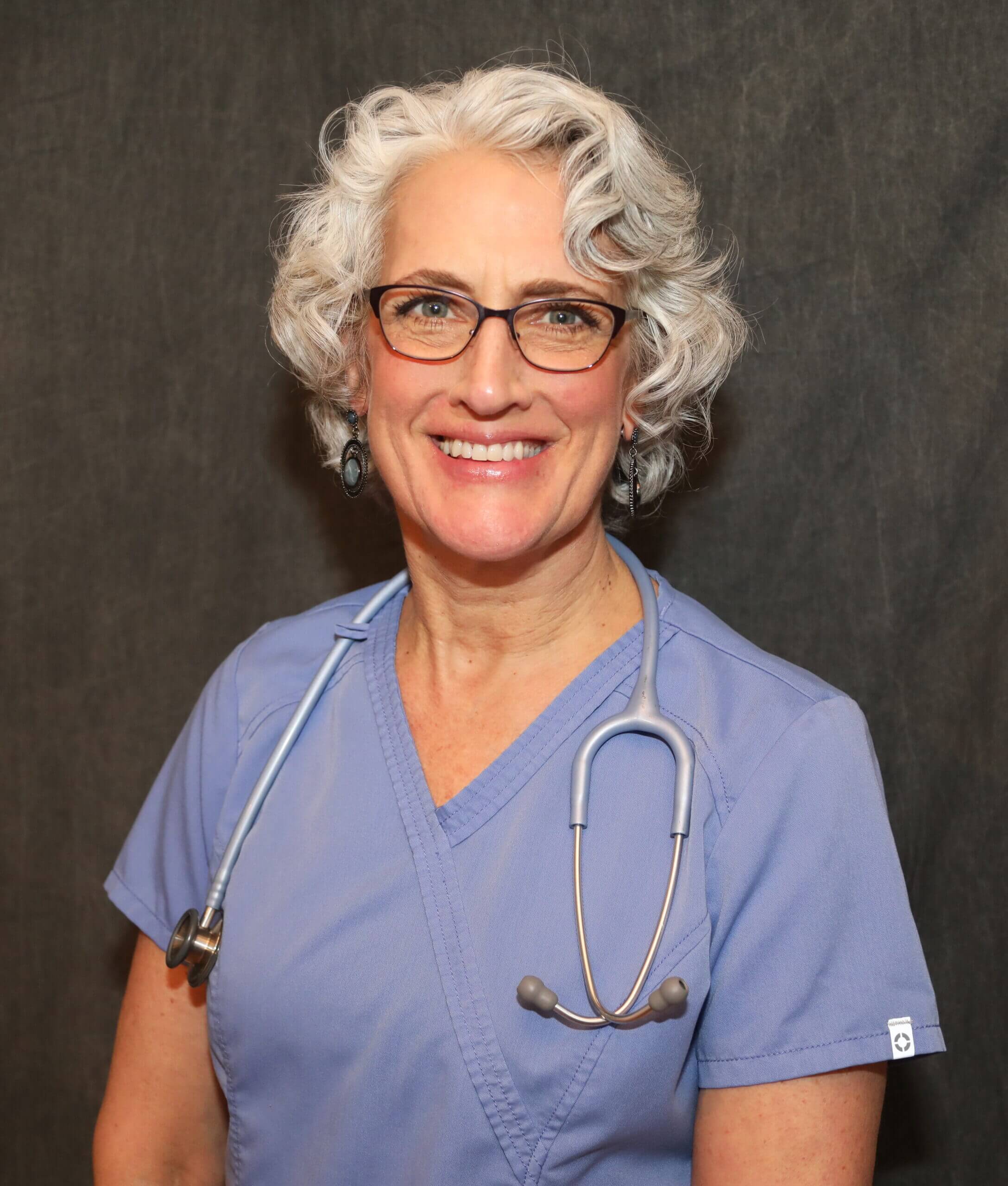 A woman with glasses and a stethoscope around her neck.